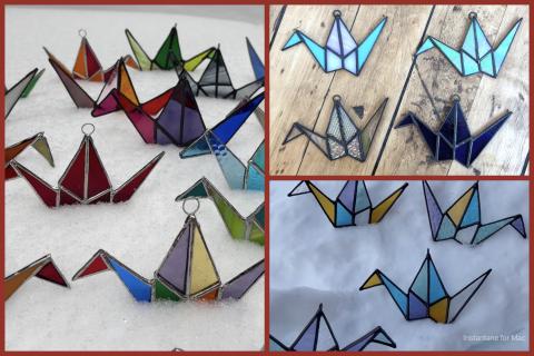 Three panels showing colorful stained glass cranes against snow and wood backgrounds.