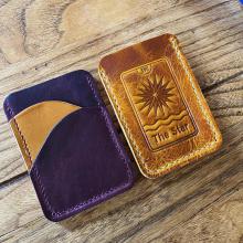 Purple and yellow card wallets with The Star tarot card debossed. 