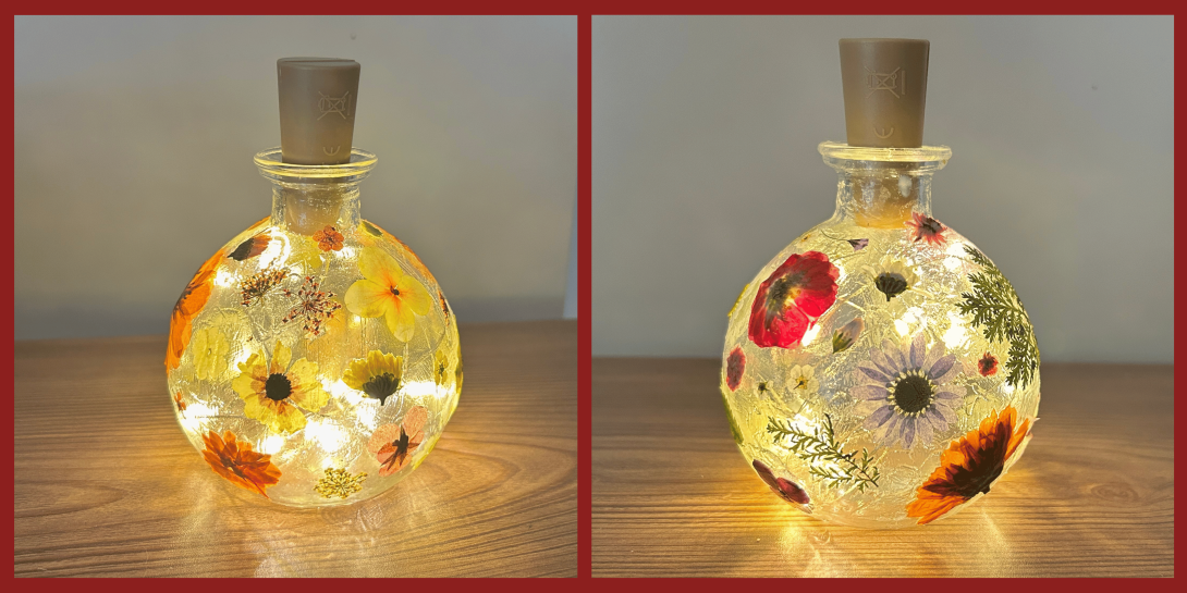 A round glass bottle filled with warm fairy lights and decorated with colorful pressed flowers, shown in two side-by-side versions featuring yellow, orange, and purple blooms.